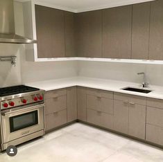 an empty kitchen with stainless steel appliances and white counter tops is pictured in this image