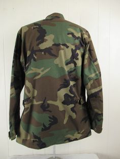 "Vintage 1980s camouflage U.S. Air Force military jacket. Made of green camo Nylon/cotton. Has U.S. Air Force patch, a button front, button cuffs, four pockets and button side cinches. Size medium long. Actual measurements are: 47\" at the chest 44\" at the waist 18\" shoulder seam to shoulder seam 26.5\" shoulder seam to end of cuff 33.5\" overall length. In excellent condition." Air Force Jacket, 1980s Jacket, Air Force Patches, Camouflage Jacket, Camo Jacket, Vintage Hawaiian, Medium Long, Green Camo, Vintage Jacket