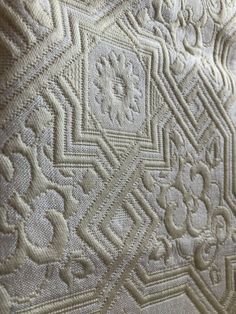 close up view of an intricate white quilt