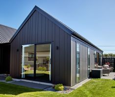 a black house with sliding glass doors on the front and side windows is shown in this photo