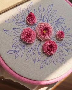 some pink flowers are sitting on top of a piece of fabric in the shape of a flower