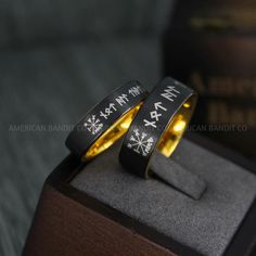 two black and gold rings with white snowflakes are sitting on top of each other