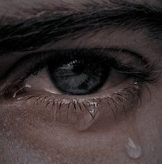 an extreme close up shot of a person's eye with tears on their eyes