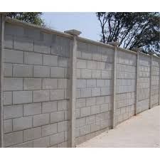 a concrete block wall next to a sidewalk