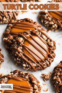 chocolate turtle cookies with caramel drizzled on top and nuts in the middle