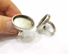 someone is holding two silver rings in their hand and they are not wearing the same ring