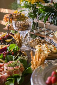 a table filled with plates and bowls of food on top of each other next to flowers