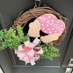 a door hanger that says it's a girl with a pink bow