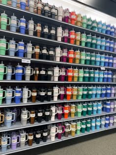 the shelves are filled with many different colored cups