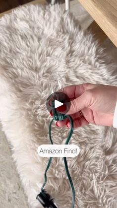 a person is holding an electrical cord and plugged in to a table with the amazon find logo on it