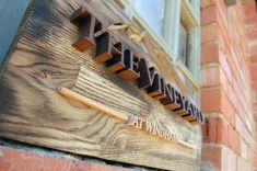 a wooden sign on the side of a building