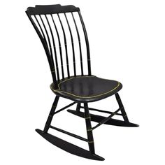 a wooden rocking chair with black and yellow trimmings on the seat, against a white background