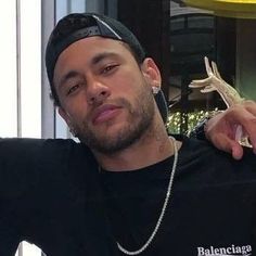 a man in a black shirt is holding a small lizard on his arm and looking at the camera