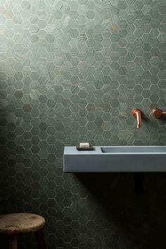 a bathroom sink sitting under a mirror next to a wooden stool