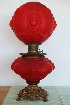 a red vase sitting on top of a wooden table