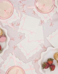 pink and white desserts on plates with strawberries in the middle next to each other