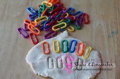 colorful paper clips sitting on top of a piece of white paper next to a cookie