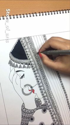 a woman is drawing on paper with a pencil