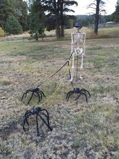 there is a skeleton on the ground with two black spider legs in front of it