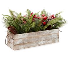 a wooden planter filled with red berries and greenery next to a pine cone