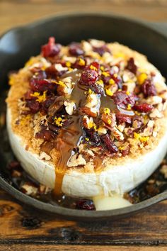 a skillet filled with food on top of a wooden table