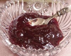 a glass bowl filled with jelly and a spoon