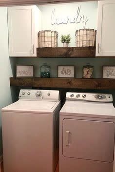 a washer and dryer in a laundry room with wooden shelves on the wall