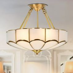 a chandelier hanging from the ceiling in a room with two lamps on it