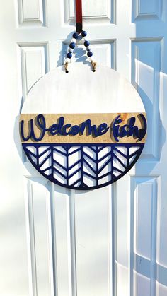 a welcome sign hanging from the side of a door