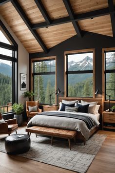 a large bed sitting in a bedroom next to two windows with mountains in the background