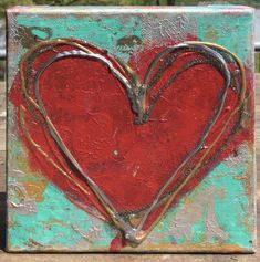 a red heart painted on top of a wooden block