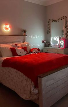 a bedroom with hello kitty lights on the wall and red bedspread in it