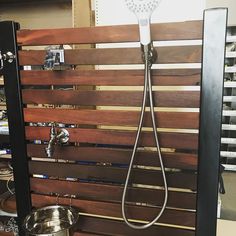 a shower head mounted to the side of a wooden slatted wall in a store