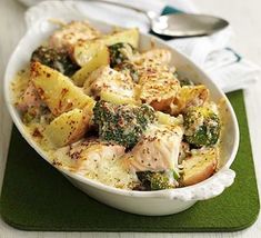 a white bowl filled with chicken and broccoli on top of a green place mat