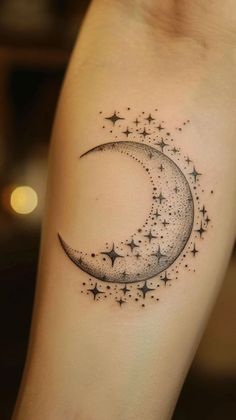 a small crescent tattoo with stars on the side of the arm and in the shape of a half moon