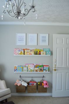 a baby's nursery room with pictures and toys on the wall, and a chandelier