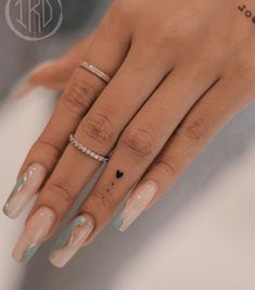 a woman's hand with two rings on it and a diamond ring in the middle