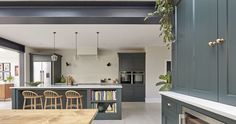 an open kitchen and dining room with green cabinets