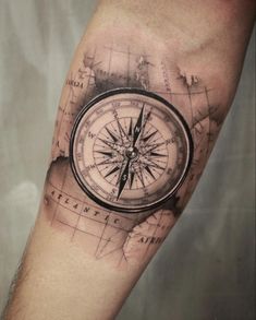 a man's arm with a compass tattoo on it