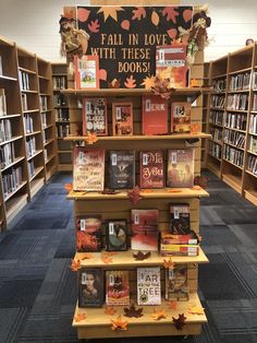 there are many books on the shelves in the library and one has fallen leaves all over it