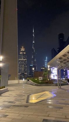 the city skyline is lit up at night, with skyscrapers in the back ground