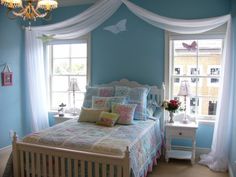 a bedroom decorated in blue and white with a monogrammed wall hanging above the bed