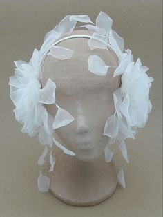 a white headpiece with flowers on it's side and netting around the top