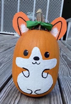 a pumpkin decorated with an image of a dog's face and ears is sitting on a wooden table