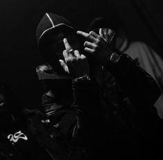 black and white photograph of a person wearing a hat with their hands on his face