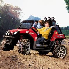 two children riding in a red toy car