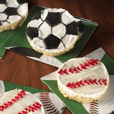 three decorated cookies with baseballs and soccer balls on paper napkins next to each other