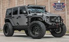 a gray jeep parked in front of a brick building