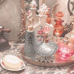 there are many glass items on the table in front of each other, including perfume bottles and soap dispensers