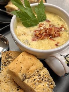 a white bowl filled with soup next to two pieces of bread